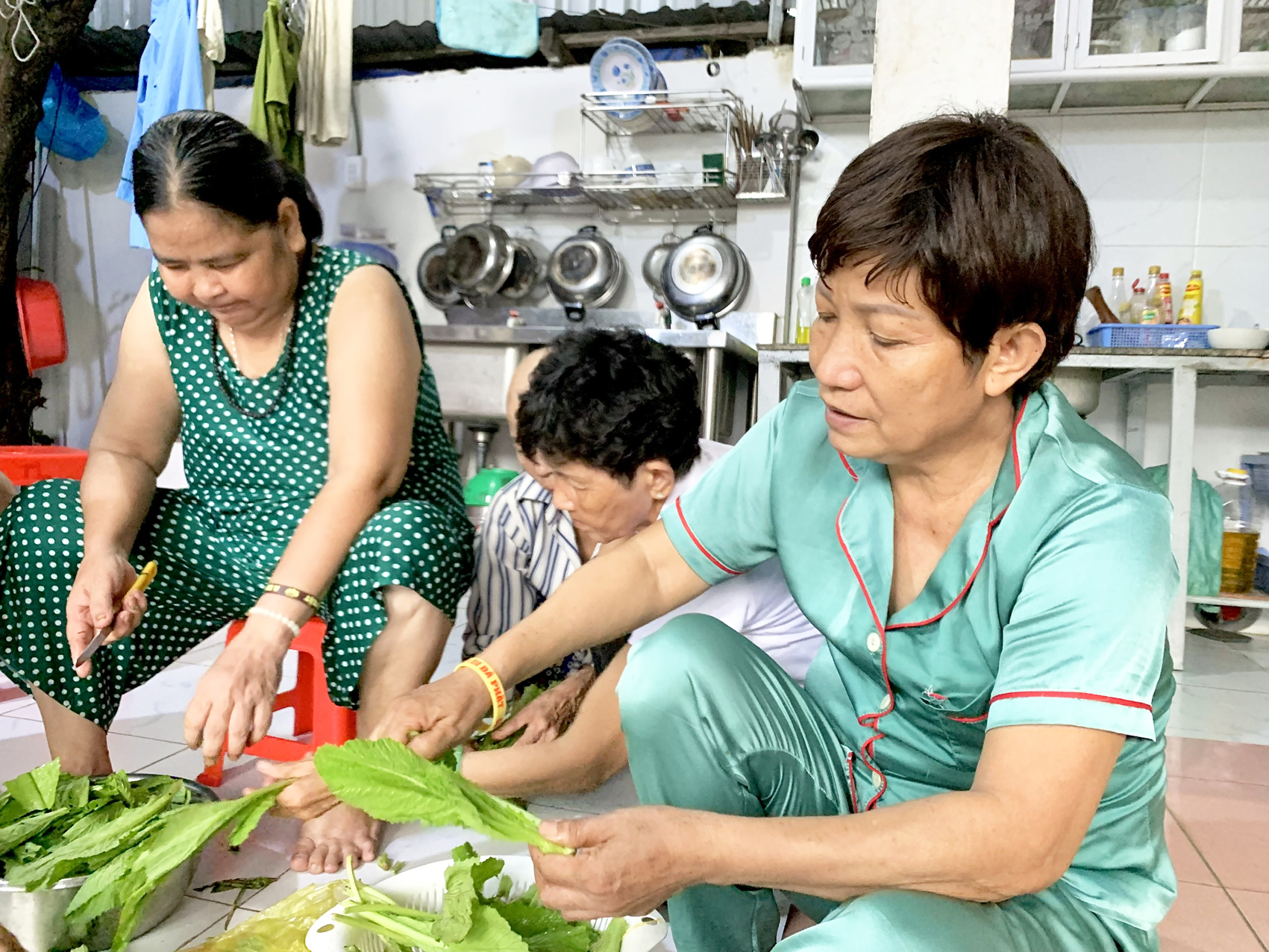 Bà Năm (bìa phải) đang cùng các bệnh nhân ung thư ở nhà trọ Thanh Liên chuẩn bị bữa ăn tối