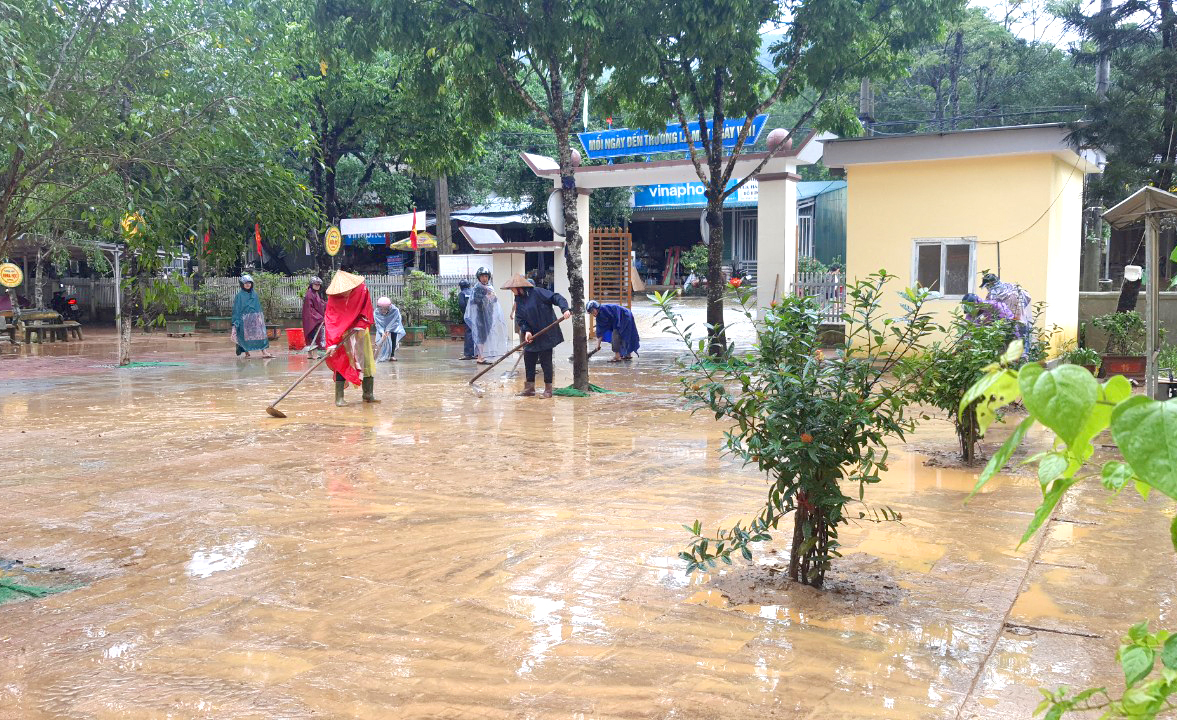 Giáo viên nhiều trường ở huyện Hương Khê tranh thủ dọn bùn đất khi nước lũ rút - Ảnh: Quốc Thanh