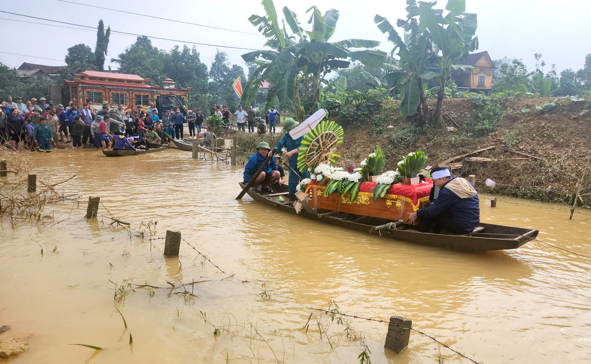 Người dân địa phương phải huy động thuyền nhỏ chờ quan tài và người thân e D. đến khu vực chôn cất - Ảnh: K.Thành