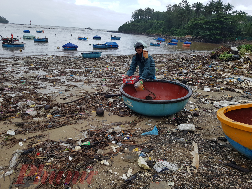 Một ngư dân vừa đánh cá xong, kéo thúng của mình lên giữa bãi rác neo lại trước khi mang cá về nhà. Dù bãi rác bẩn nhưng ông không còn lựa chọn nào khác