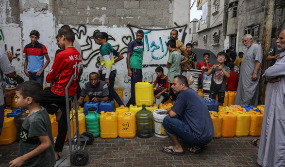 Xếp hàng lấy nước ở Rafah. Người dân phải chờ hàng giờ để lấy nước ở Gaza sau khi Israel cắt nguồn cung nhưng nước thường bị ô nhiễm hoặc nhiễm nước lợ. Ảnh: Anadolu/Getty