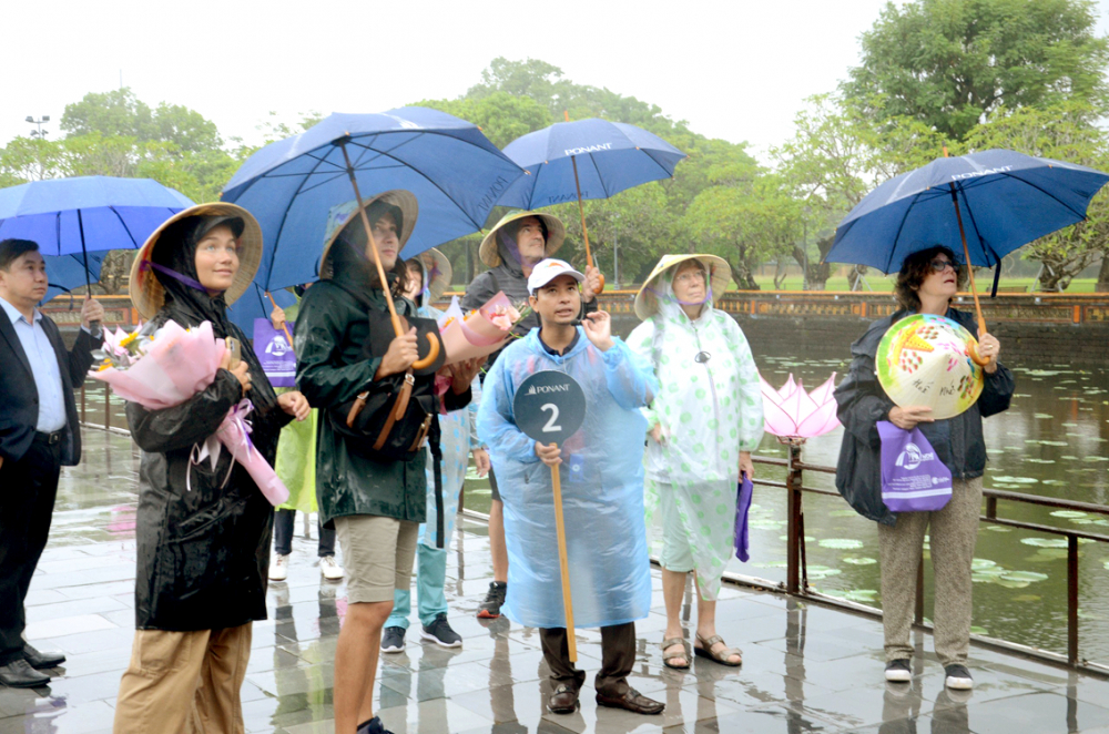 Du khách trải nghiệm mưa dầm ở Đại Nội (TP Huế) - ẢNH: THUẬN HÓA