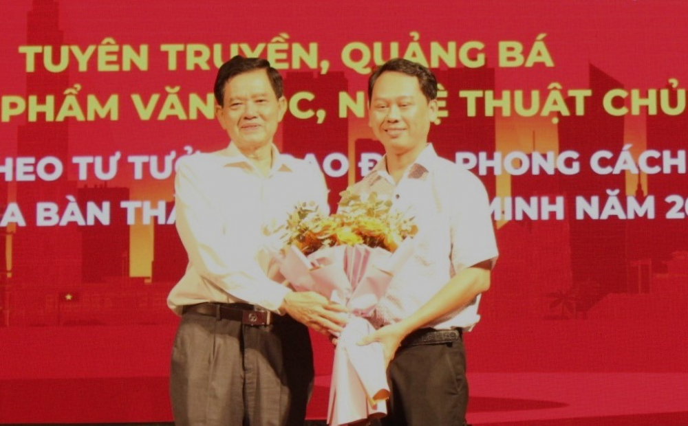 Phó bí thư thường trực quận ủy Phú Nhuận Huỳnh Đăng Linh tặng hoa cho phó giám đốc Nhà hát Kịch TPHCM Trần Quý Bình.