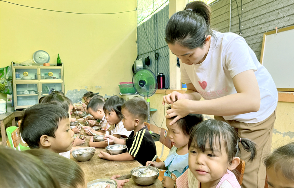 Cô Lương Thủy Trang chăm sóc tận tình từng bữa ăn cho các em học sinh người Khơ Mú ở điểm trường Đỉnh Sơn 2