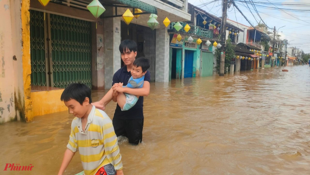 Lo sợ tình hình mưa lũ diễn biến phức tạp, bà con phố cổ Bao Vinh tranh thủ đưa trẻ con người nhà di tản đến nơi cao để tránh lũ