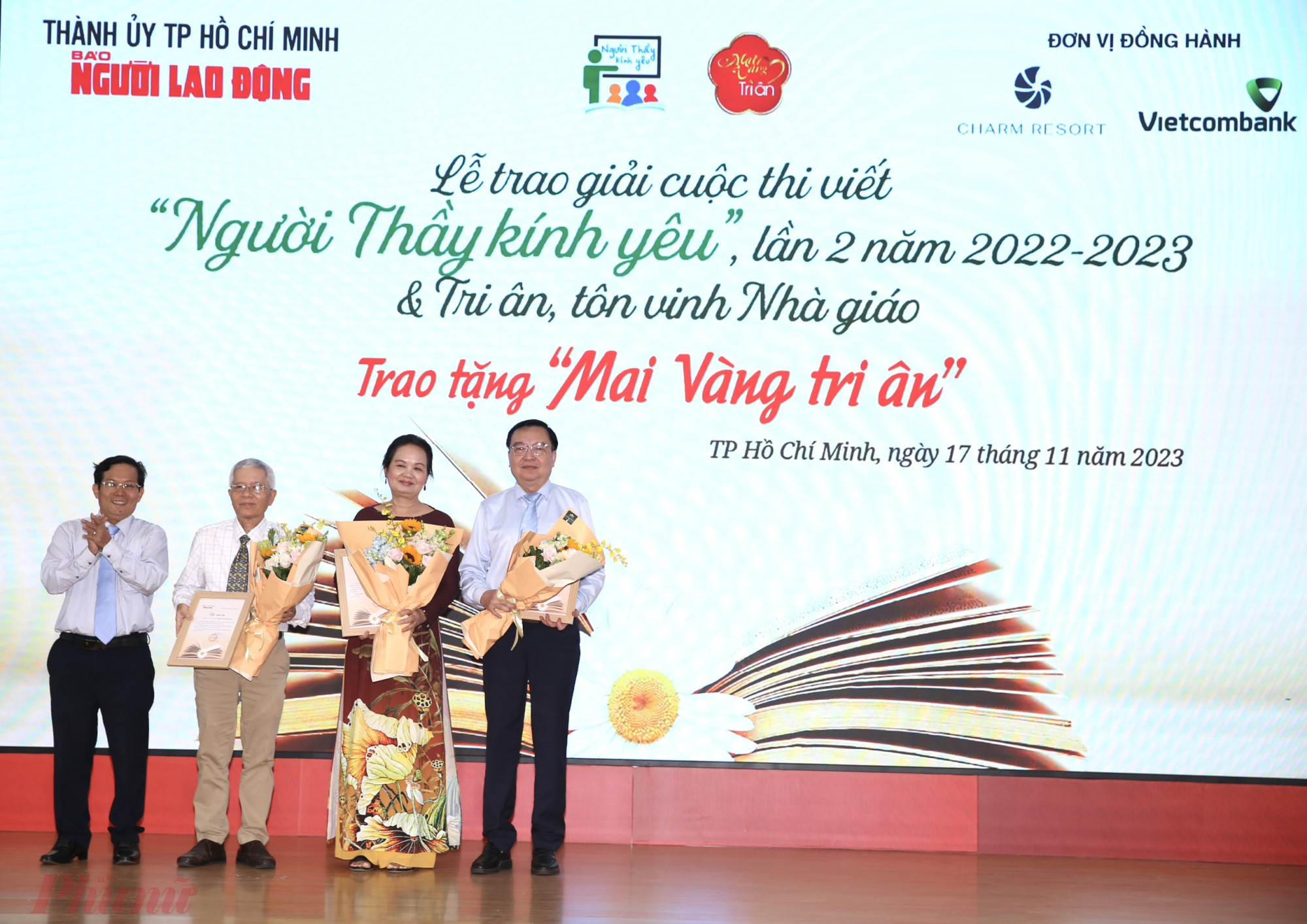 Ảnh 2: Ông Tô Đình Tuân - Tổng biên tập Báo Người Lao Động - tặng hoa cảm ơn 3 thành viên ban giám khảo cuộc thi.