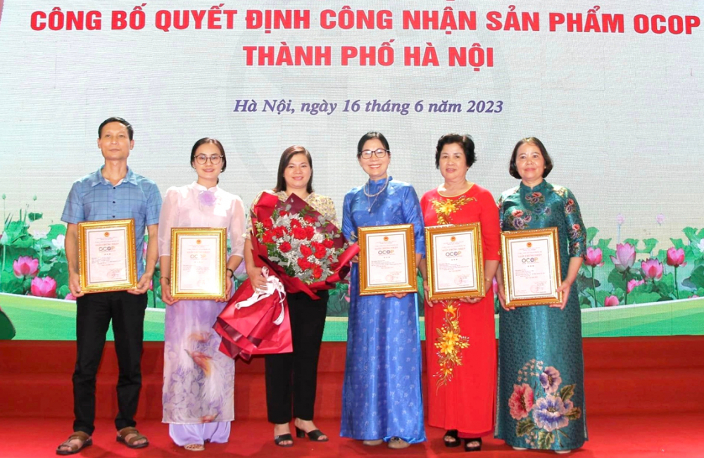 Bà Nguyễn Thị Liên (thứ ba từ phải qua) nhận quyết định công nhận sản phẩm OCOP 3 sao của TP Hà Nội