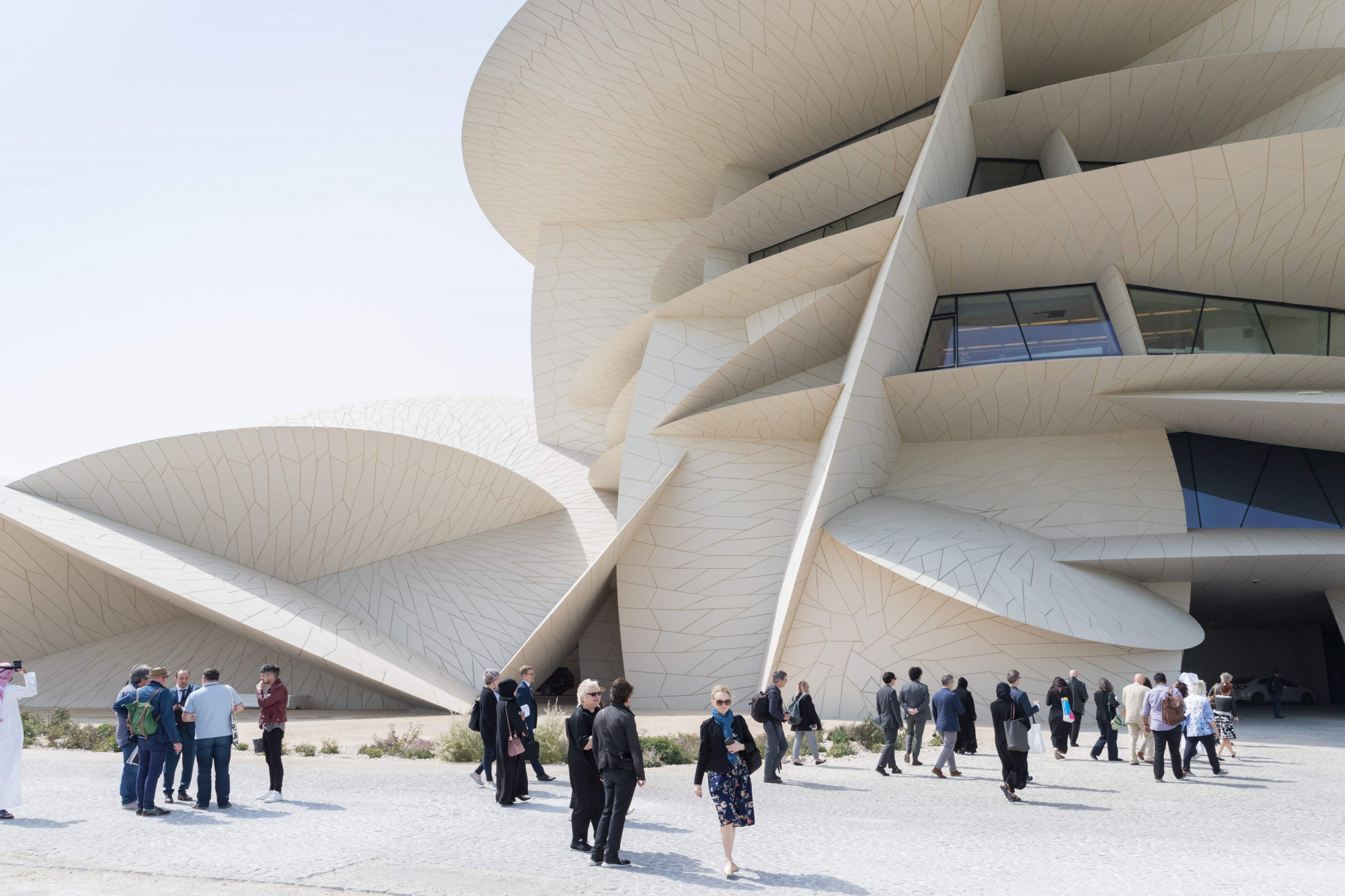 Được thiết kế bởi kiến ​​trúc sư đoạt giải Pritzker Jean Nouvel, người cũng là người đứng sau bảo tàng Louvre Abu Dhabi , tòa nhà trị giá 434 triệu USD này là một dãy các hình đĩa cong, các góc đúc hẫng và các nút giao cắt đáng ngạc nhiên, đồng thời được lấy cảm hứng từ các cụm pha lê “hoa hồng sa mạc” hình thành trong sa mạc Qatar.  Khách mời nổi tiếng tại lễ khai mạc xa hoa bao gồm Johnny Depp, Naomi Campbell và Victoria Beckham. Tờ UK Times gọi đây là “tòa nhà phi thường nhất thập kỷ”, tờ Financial Times mô tả nó là “bông hồng sa mạc có quy mô đột biến”, trong khi The Guardian tự hỏi liệu “sáng tạo bắt mắt” này có “quá xa hoa để lấp đầy hay không”.  Vậy điều gì ẩn chứa bên trong siêu bảo tàng mới tuyệt vời này?
