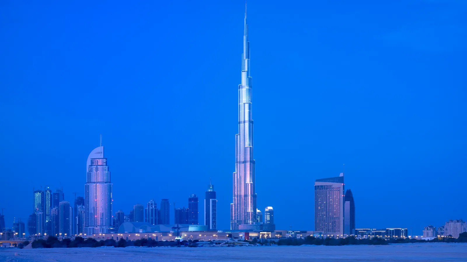 Burj Khalifa nằm ở Khu thương mại Dubai ở Các Tiểu vương quốc Ả Rập Thống nhất, gần Đường đi bộ lát đá Đài phun nước Dubai. Ngày nay, tòa nhà được bao quanh bởi các văn phòng, cửa hàng và nhà hàng khác, trong đó có Trung tâm mua sắm Dubai, nơi có nhiều nhà bán lẻ thiết kế như Hermés, Saint Laurant, Cartier và Balenciaga, cùng các điểm đến đáng chú ý khác như Burj Al Arab và Palm Jumeirah gần đó. Mặc dù thành phố hiện nay nổi tiếng với lối sống hào nhoáng và giàu có, nhưng khi dự án mới bắt đầu, khu vực này chỉ là một mảnh đất với vài tòa nhà nằm rải rác đây đó.