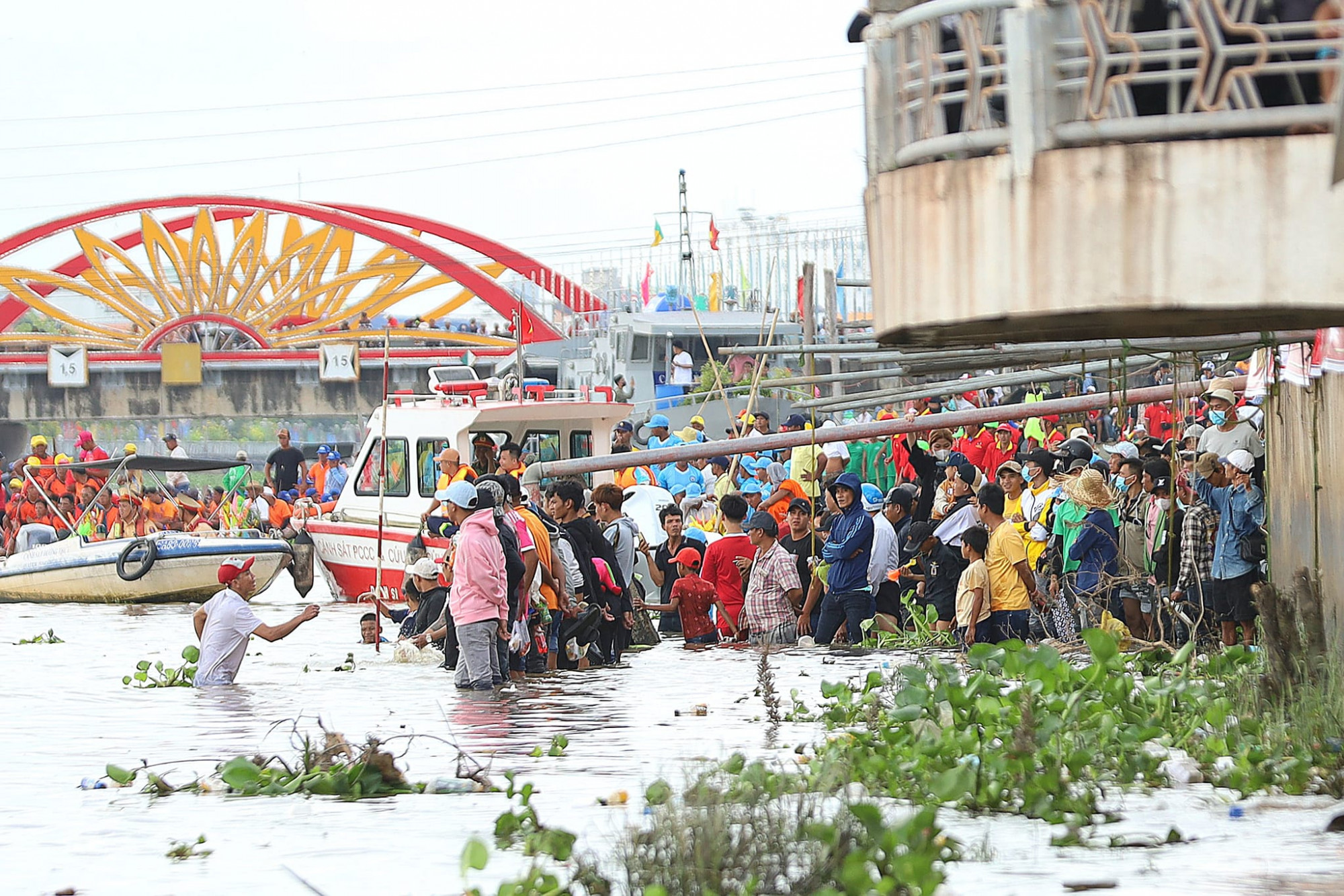 Nhiều người lội xuống sông để cổ vũ cho các đội đua.
