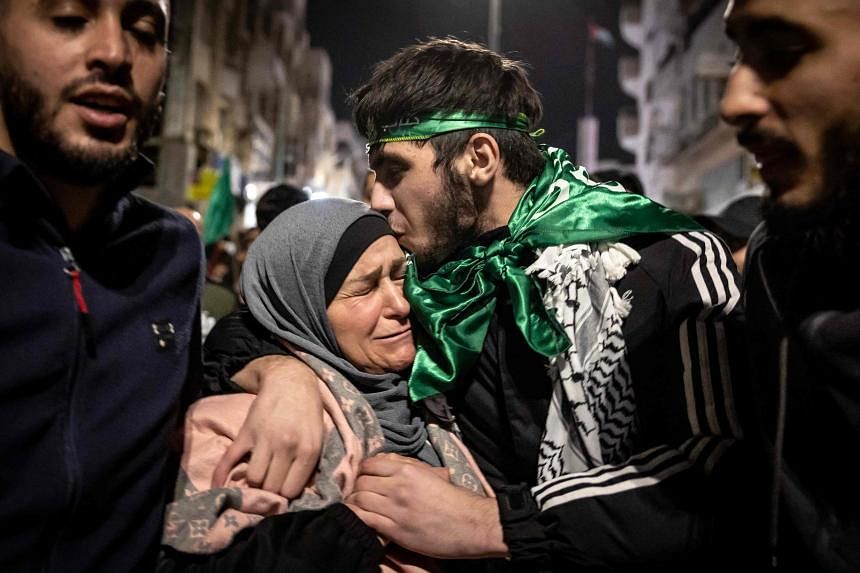 Một con tin người Palestine ôm mẹ sau khi được thả khỏi nhà tù của Israel, 