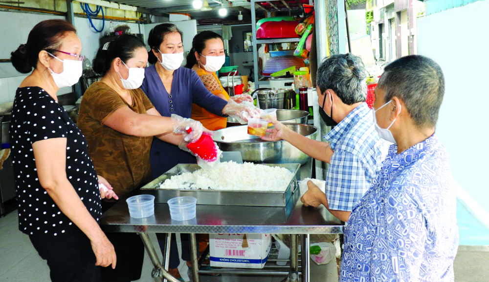 Người nhà bệnh nhân nhận cơm chay tại Bếp chay thiện nguyện chùa Bảo Vân, bếp ăn đảm bảo vệ sinh (quận Bình Thạnh) - Ảnh: Thái Phương