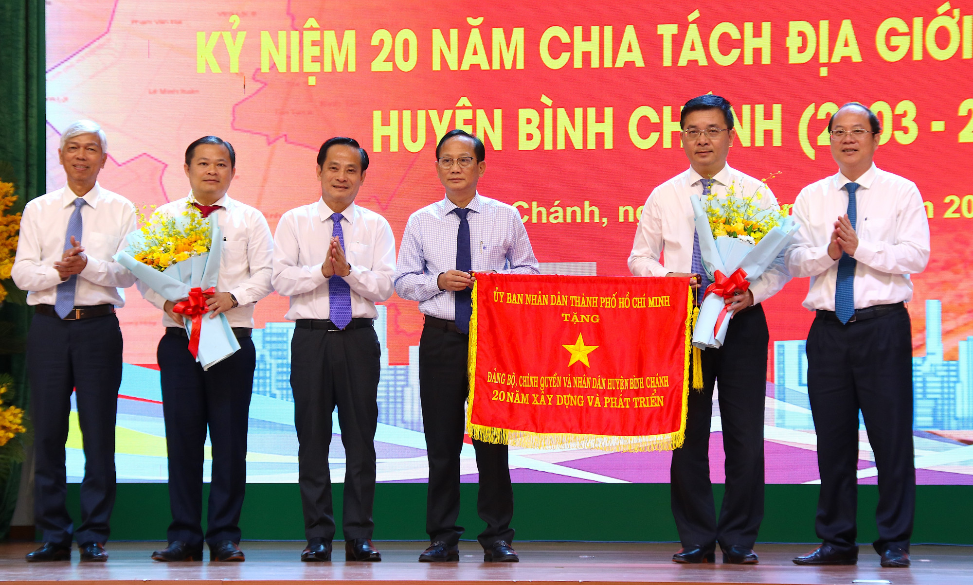 Phó Bí thư Thành ủy TPHCM Nguyễn Hồ Hải và Phó Chủ tịch UBND TPHCM Võ Văn Hoan trao Cờ truyền thống đến Đảng bộ, chính quyền và nhân dân huyện Bình Chánh