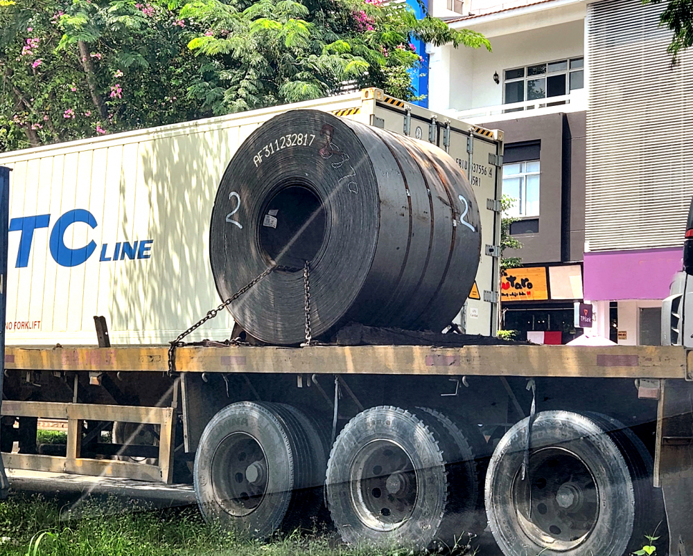 Xe chở cuộn thép nặng 20 tấn được chằng buộc sơ sài bằng sợi xích nhỏ, cũ, dùng miếng gỗ mục để chêm, trên đường Nguyễn Văn Linh, quận 7, TPHCM