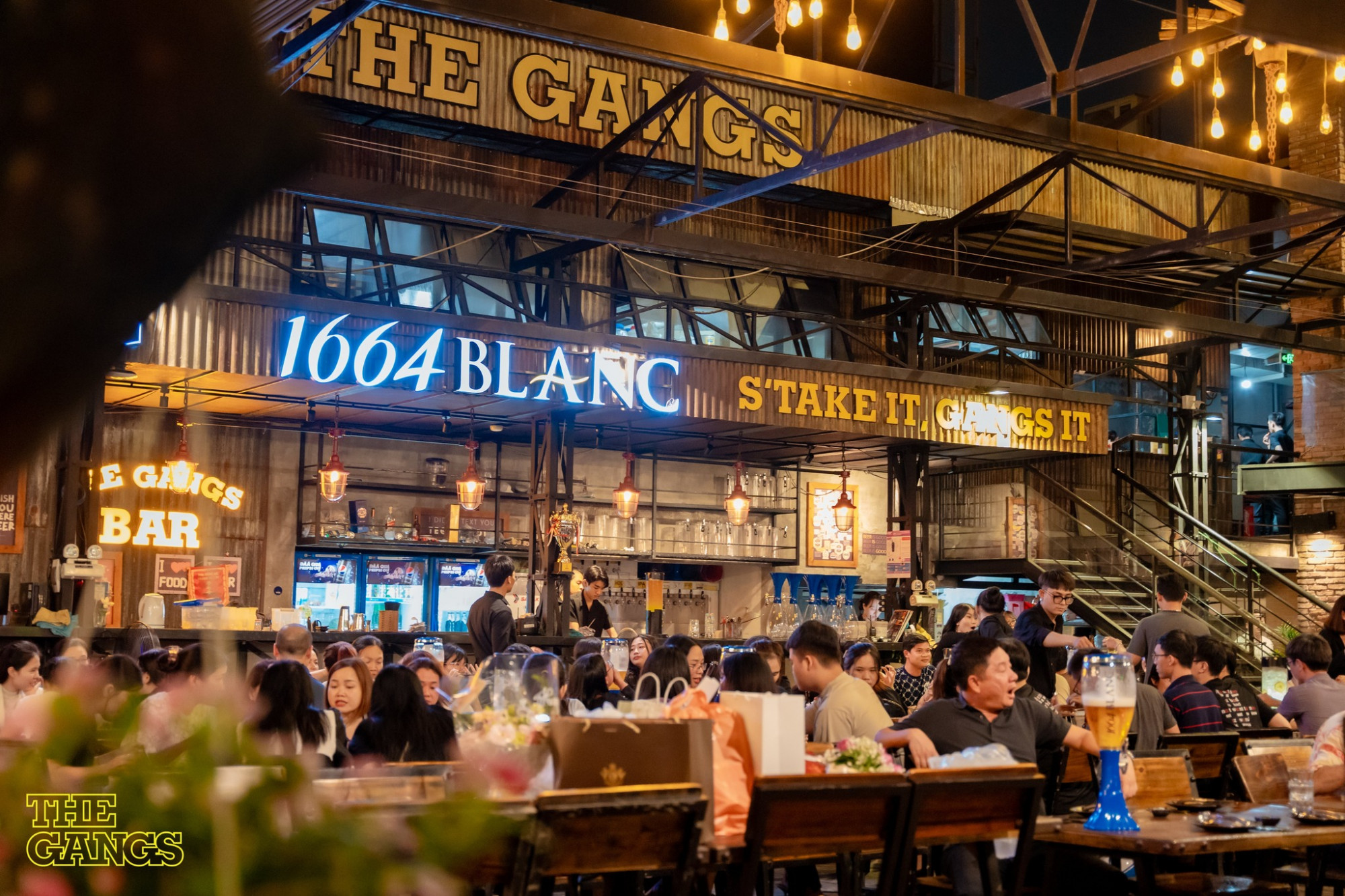 THE GANGS chuyên phục vụ các món Việt, Âu và Nhật cùng nhiều loại bia tươi, bia thủ công và vang đầy độc đáo. Đặc biệt là dòng bia thủ công mang tên The Gangs được đông đảo các Gangsta đón nhận bởi hương vị riêng biệt, đậm đà nhưng vẫn dễ uống. Không gian mở thiết kế phóng khoáng, hiện đại mang đến trải nghiệm thú vị cho thực khách. Phong cách nhà hàng phù hợp cho những bữa tiệc cuối tuần, họp mặt của gia đình và đồng nghiệp hay những cuộc nhậu cực chill cùng bạn bè. Các Gangsta còn không thể bỏ qua những đêm nhạc với các chủ đề khác nhau cùng dàn nghệ sĩ cực chất tại THE GANGS.