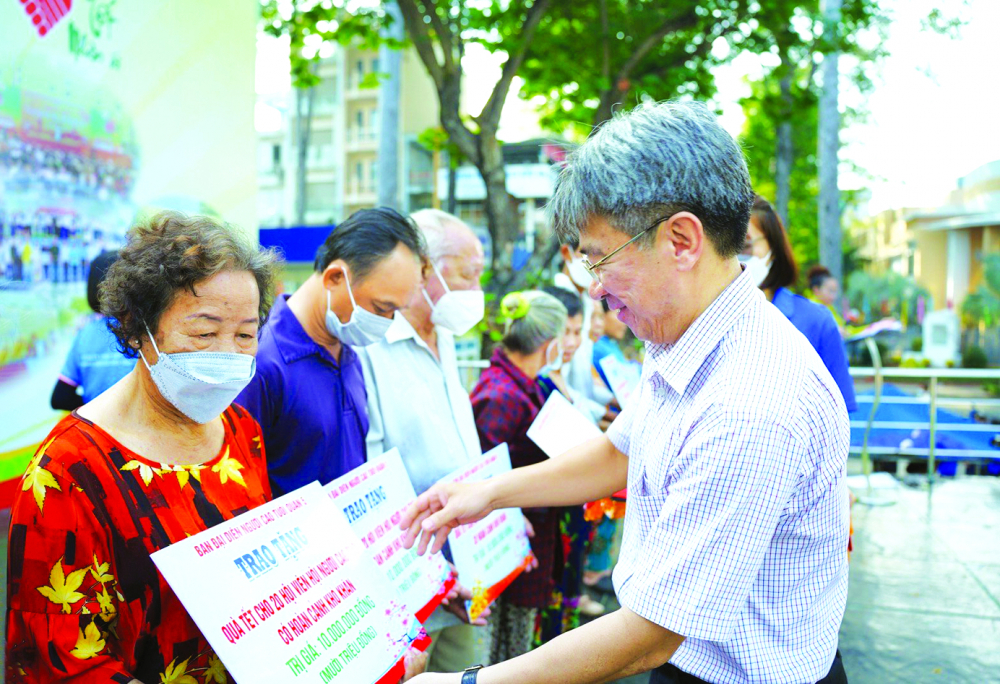 Ông Nguyễn Võ Xuân Kỳ - Phó chủ tịch UBND quận 5 - trao quà tết Quý Mão 2023 cho người cao tuổi khó khăn. Ngày 1/12 vừa qua, quận 5 được công nhận không còn hộ nghèo, hộ cận nghèo theo chuẩn nghèo đa chiều của TPHCM - ẢNH: TAM NGUYÊN