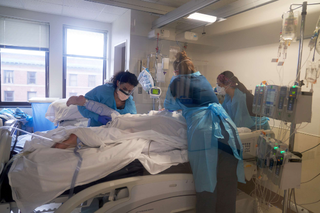 Nhân viên y tế điều trị cho một bệnh nhân trên tầng ICU Covid-19 của Bệnh viện Memorial Đại học Massachusetts ở Worcester, Mass., Ngày 27 tháng 12 năm 2021.