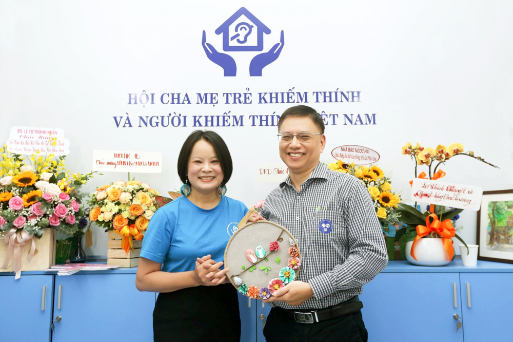 Chị Chử Thị Thanh Hương trao bức tranh được đấu giá để gây quỹ - ẢNH: HOÀNG TRUNG THIÊN