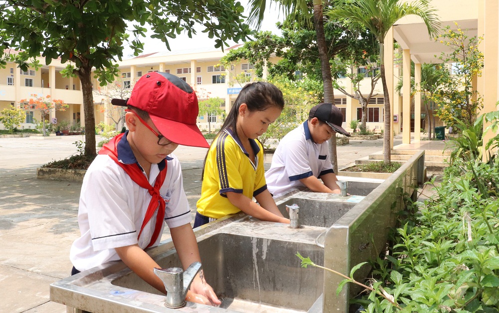 Học sinh tại huyện Cần Giờ (TPHCM) sử dụng nước sạch - Ảnh: SAWACO