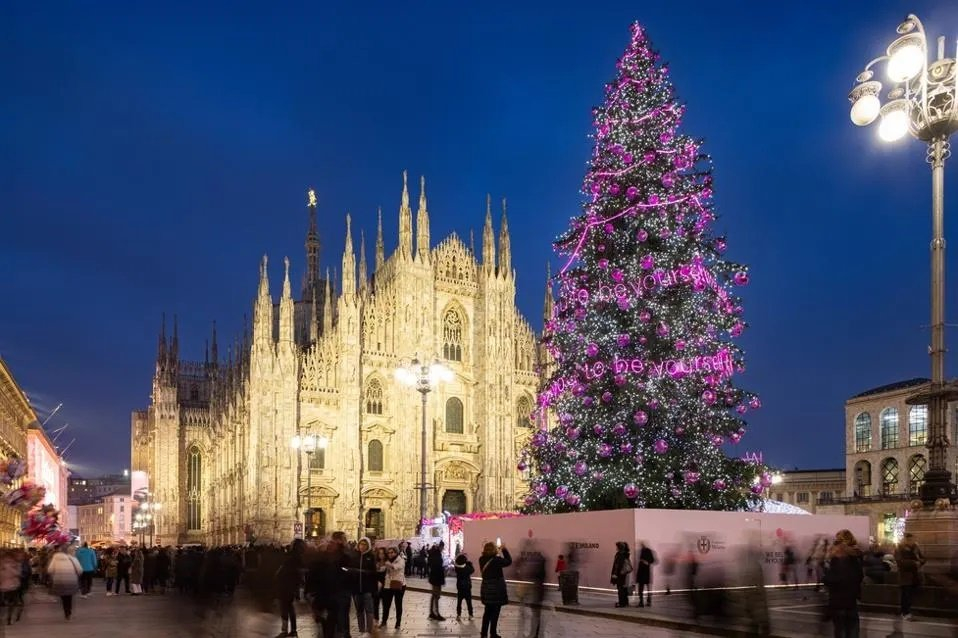Cây thông ở Piazza Duomo, Milan, Ý cao 25 ​​mét. Dây đèn  trang trí chạy quanh cây có dòng chữ “Chúng tôi mong bạn là chính mình.”