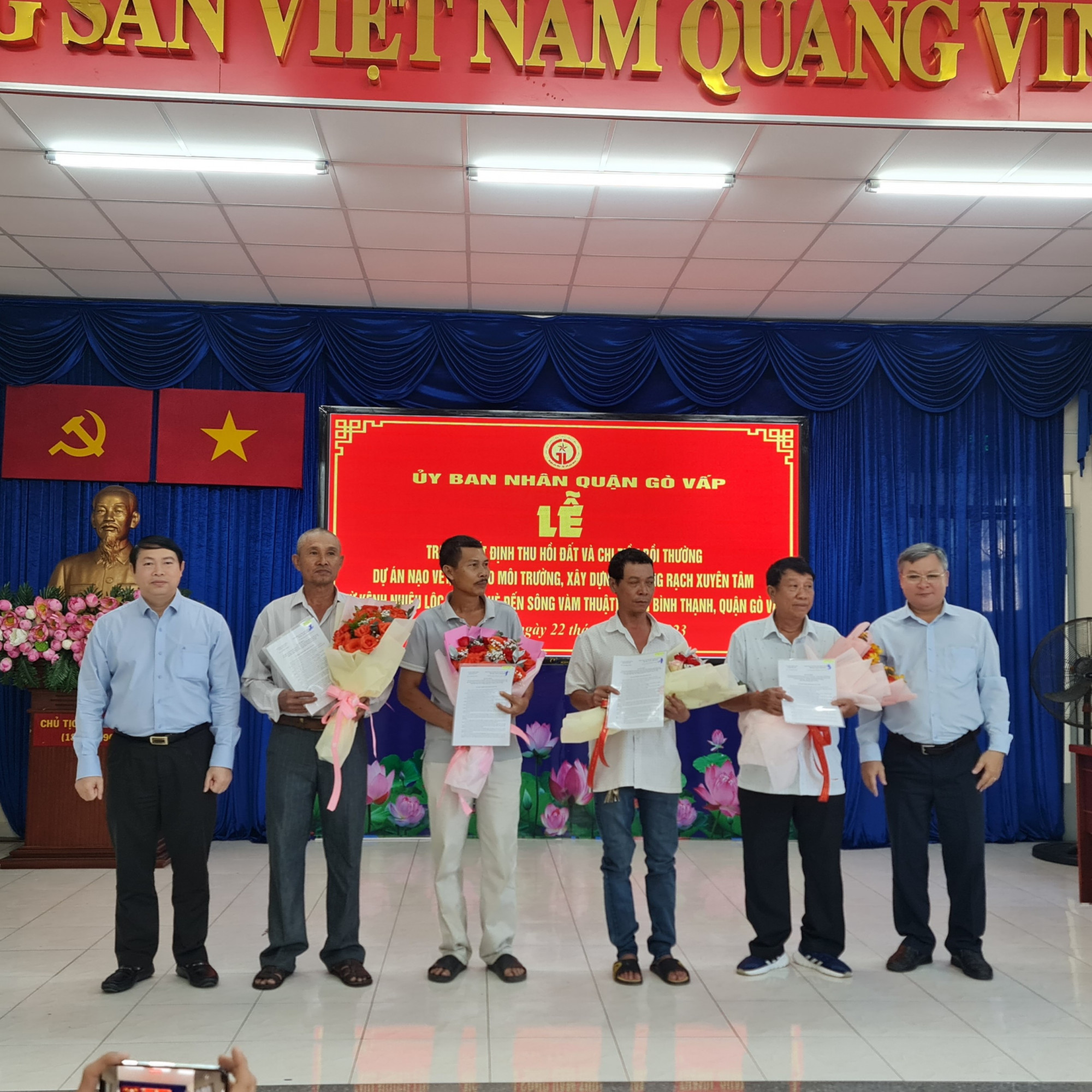 Ông Nguyễn Trí Dũng, Chủ tịch UBND quận Gò Vấp (bìa trái) và ông Nguyễn Hoàng Anh Dũng, Phó Giám đốc Ban quản lý dự án đầu tư xây dựng hạ tầng đô thị TP.HCM (bìa phải) trao quyết định thu hồi đất cho người dân. Ảnh: NC