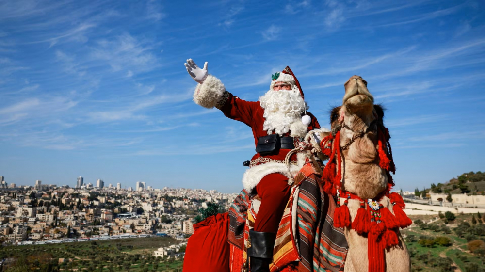Issa Kassissieh, trong trang phục ông già Noel, cưỡi lạc đà khi đến thăm một lùm ô liu nhìn ra Mái vòm Đá trên khu phức hợp Al-Aqsa, còn được người Do Thái gọi là Núi Đền, ở thánh địa Jerusalem