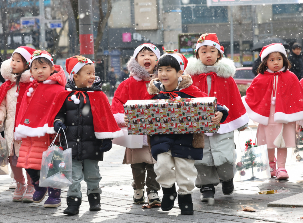 Trẻ em từ một trung tâm giữ trẻ ở thành phố Gwangju, Hàn Quốc trong trang phục ông già Noel mang theo những món quà mà các em làm để tặng người có hoàn cảnh khó khăn