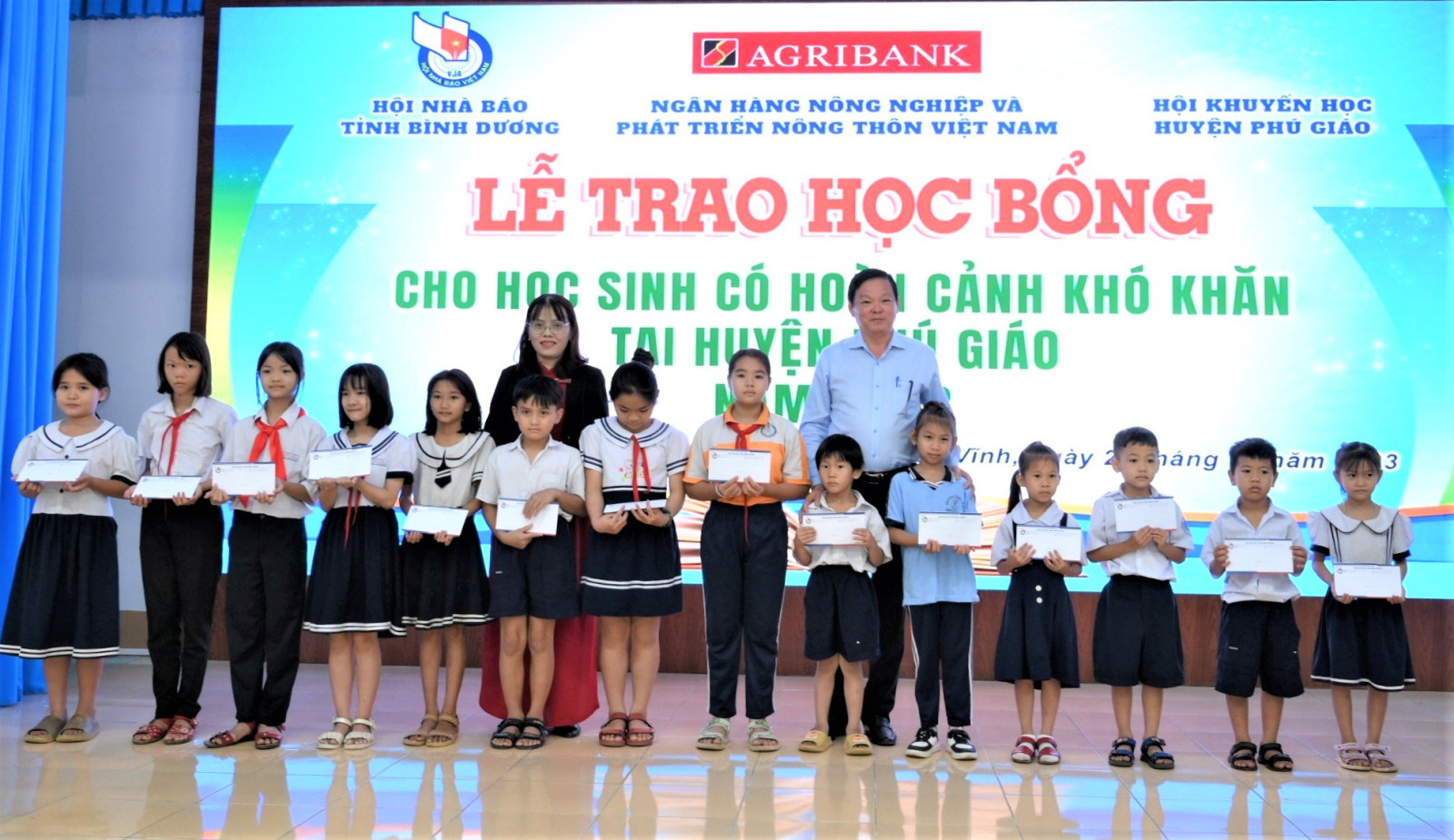 Đại diện Hội nhà Báo tỉnh Bình Dương và Ngân hàng  Agribank trao học bổng cho các em học sinh có hoàn cảnh khó khăn.