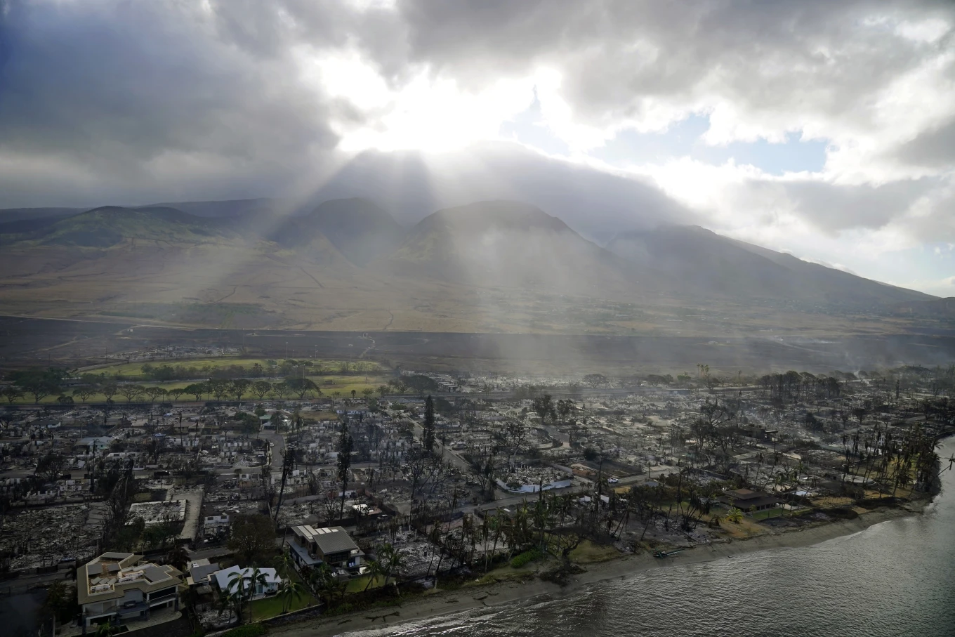 Ánh nắng xuyên qua đám mây trên đống đổ nát từ trận cháy rừng ở thị trấn Lahaina, Hawaii, ngày 10/8. Ảnh: AP/Rick Bowmer