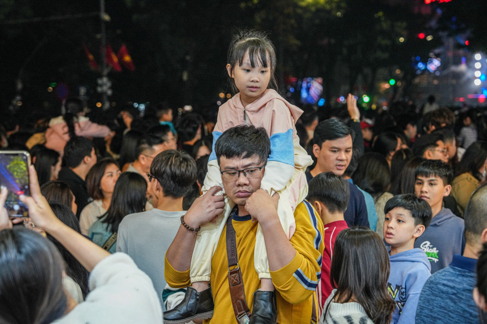 Các em nhỏ được cha mẹ công kênh trên vai rời khỏi đám đông sau chương trình Countdown.