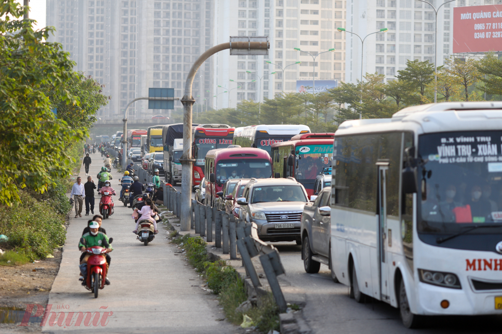 Các phương tiện xe khách nối đuôi nhau chờ qua điểm cuối cao tốc để vào trung tâm Hà Nội.