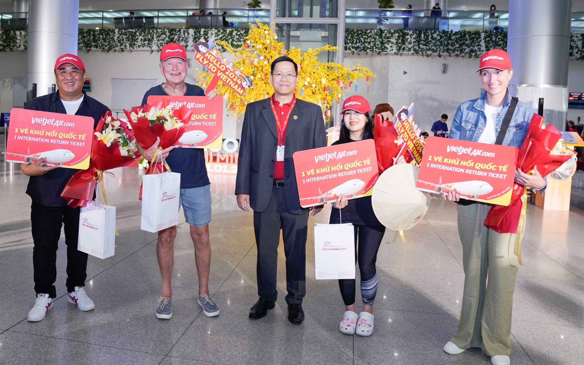 Ông Nguyễn Bác Toán - Phó tổng giám đốc Thương mại Vietjet - chào đón những hành khách đầu tiên từ Melbourne (Australia) đến TPHCM ngày 1/1/2024 - Ảnh: Vietjet