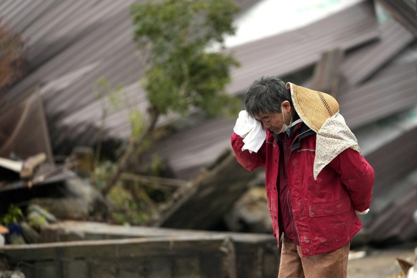 Một người đàn ông bật khóc sau khi thi thể của một thành viên trong gia đình được tìm thấy trong ngôi nhà bị sập ở Suzu, tỉnh Ishikawa, ngày 3/1.