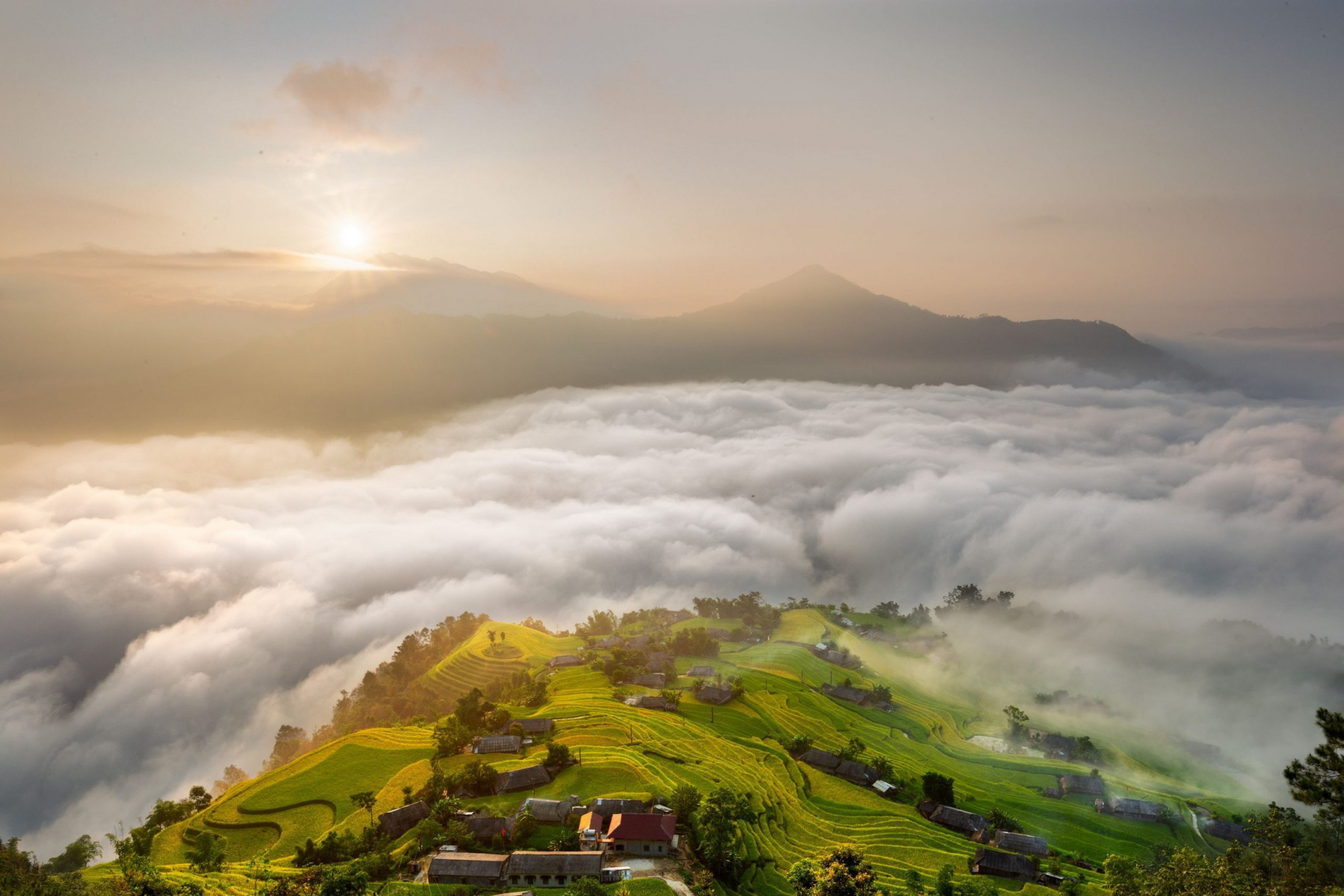 Thích săn mây và ngắm ruộng bậc thang, bạn không thể bỏ qua Bản Phùng ở huyện Hoàng Su Phì, tỉnh Hà Giang. Đây là một trong những bản làng đẹp nhất cao nguyên đá, thu hút nhiều du khách đến thăm khi du lịch miền Bắc. Những năm gần đây bản làng này được đầu tư để phục vụ du khách, đặc biệt là vào mùa thu lúa chín.Về bản Phùng, du khách sẽ được chiêu đãi bức tranh cực kỳ hoành tráng với tầng tầng lớp lớp ruộng bậc thang. Ở bản, địa hình chủ yếu là đồi núi nên diện tích ruộng thang khá nhiều. Vào mùa lúa xanh và mùa lúa chín, vẻ đẹp của bản Phùng như bước ra từ cổ tích. Đặc biệt nhất là thời điểm sớm tinh mơ mây trắng bao phủ.Khám phá Bản Phùng Hà Giang, du khách chỉ việc dậy sớm hơn thường ngày một chút là có thể thỏa thích săn mây. Sáng sớm, mây trắng nhẹ nhàng kéo đến, ôm lấy những thửa ruộng cong cong, những ngôi nhà sàn màu xám đã bạc màu. Màu mây trắng, màu lúa xanh, màu của nhà cửa đơn sơ mộc mạc. Tất cả vẽ nên một bức tranh vô cùng đẹp mà không phải nơi nào cũng có.Mùa nào ở Bản Phùng cũng đẹp, cũng thích hợp cho hoạt động săn mây và thưởng thức phong cảnh bình yên, êm ả. Cái đẹp của Bản Phùng là vẻ đẹp của sự hoang sơ, nhẹ nhàng và phảng phất chút buồn. Nhưng nếu bạn muốn đi săn mây và đi trốn thì đây là điểm đến đẹp ở Hà Giang không thể bỏ qua.