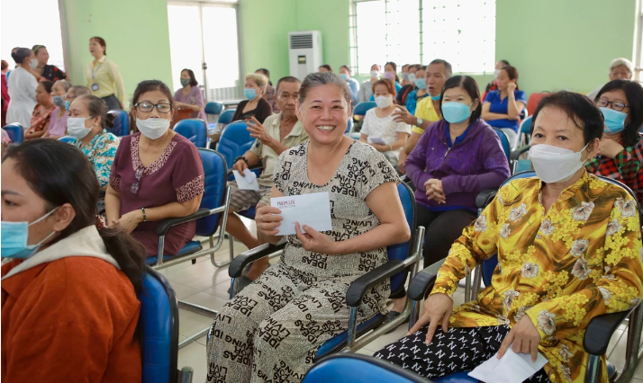 Bà con phấn khởi nhận quà từ các đơn vị tài trợ