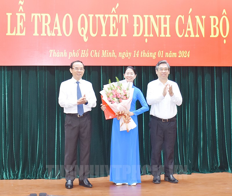 Bí thư Thành ủy TPHCM Nguyễn Văn Nên (bìa trái) và Phó Bí thư Thành ủy TPHCM Nguyễn Phước Lộc (bìa phải) trao quyết định và tặng hoa chúc mừng bà  Phan Thị Thanh Phương - Ảnh: Thành uỷ TPHCM