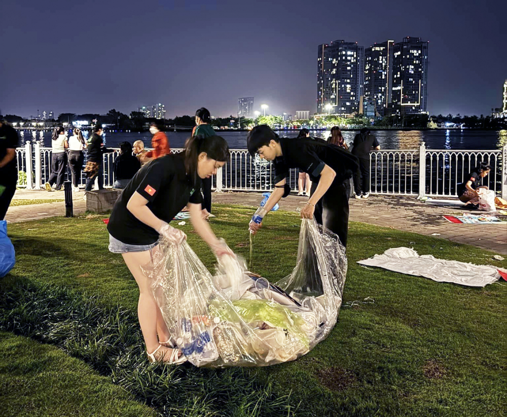Các bạn trẻ của nhóm Sài Gòn Xanh gom rác ở công viên Bến Bạch Đằng để góp phần làm giảm gánh nặng cho công nhân vệ sinh trong ngày đầu năm mới 2024 - ẢNH: NHÓM SÀI GÒN XANH