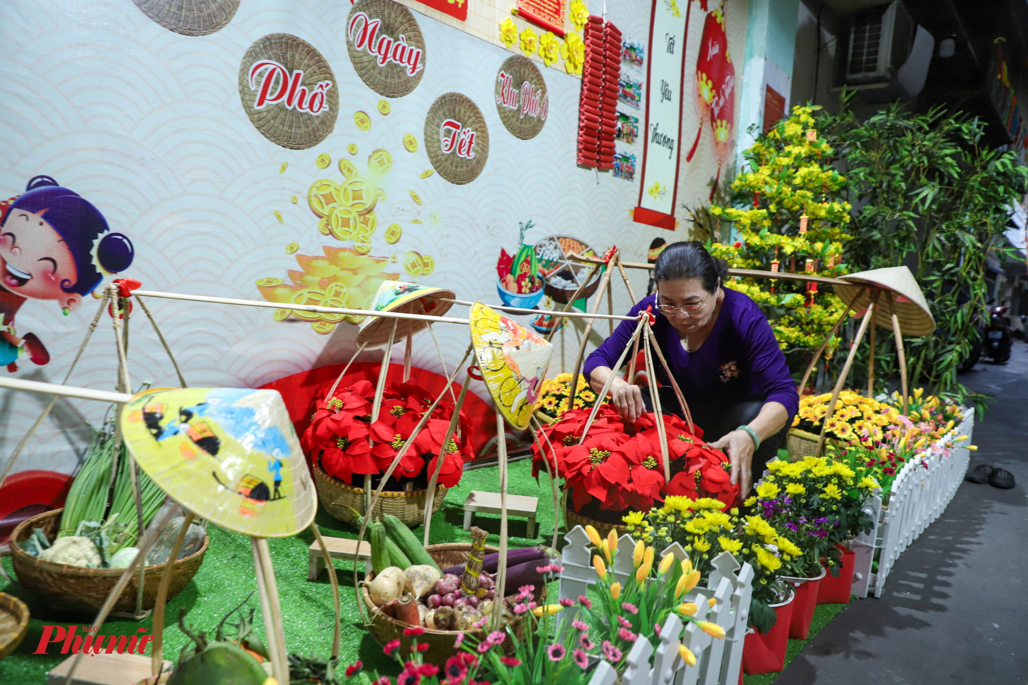 Bà Phan Thị Cẩm Hồng - người dân tại khu phố trên đường Nguyễn Thái Bình đang chăm sóc lại các chậu hoa được trang trí.