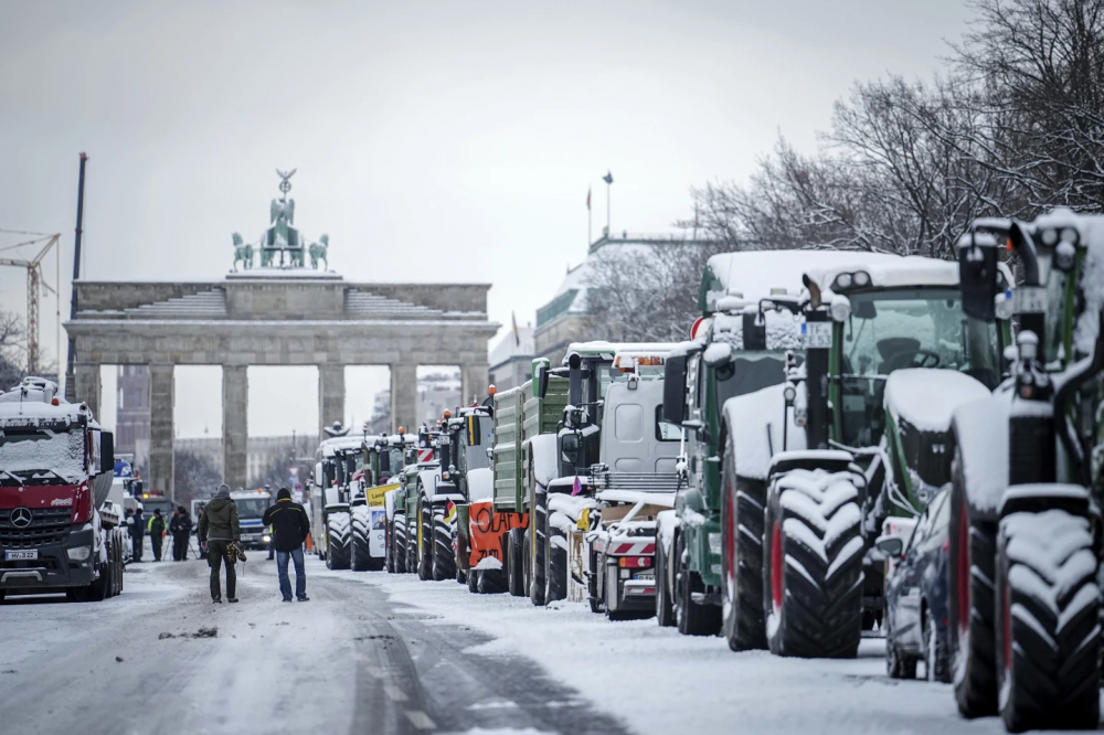 Nông dân huy động máy cày biểu tình ở thủ đô Berlin của Đức vào Thứ Ba ngày 16/1, phía sau là Cổng Brandenburg — Ảnh: AP