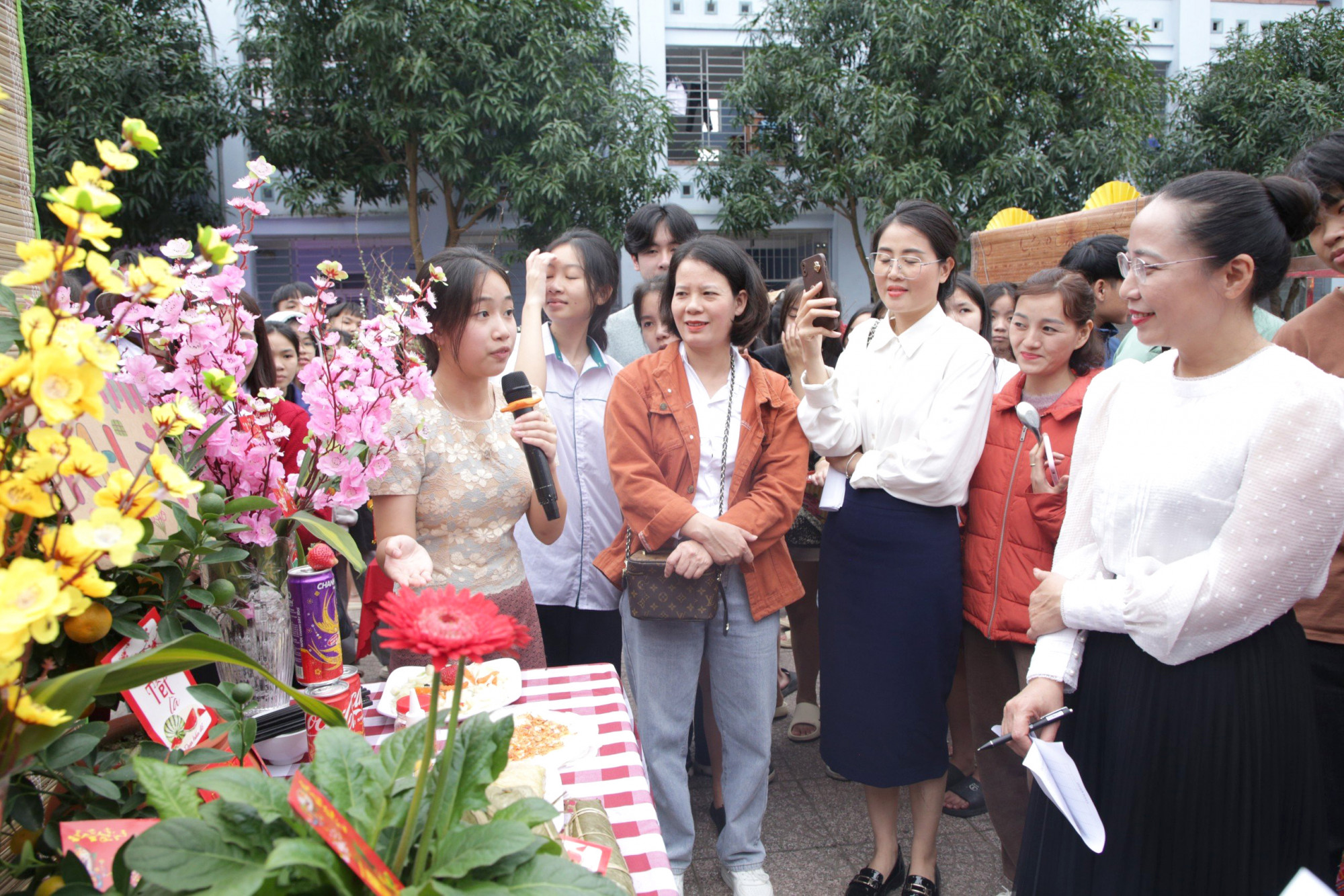 Một nữ sinh Lào giới thiệu món ăn truyền thống tới các thầy cô và các bạn - Ảnh: Văn Đạt