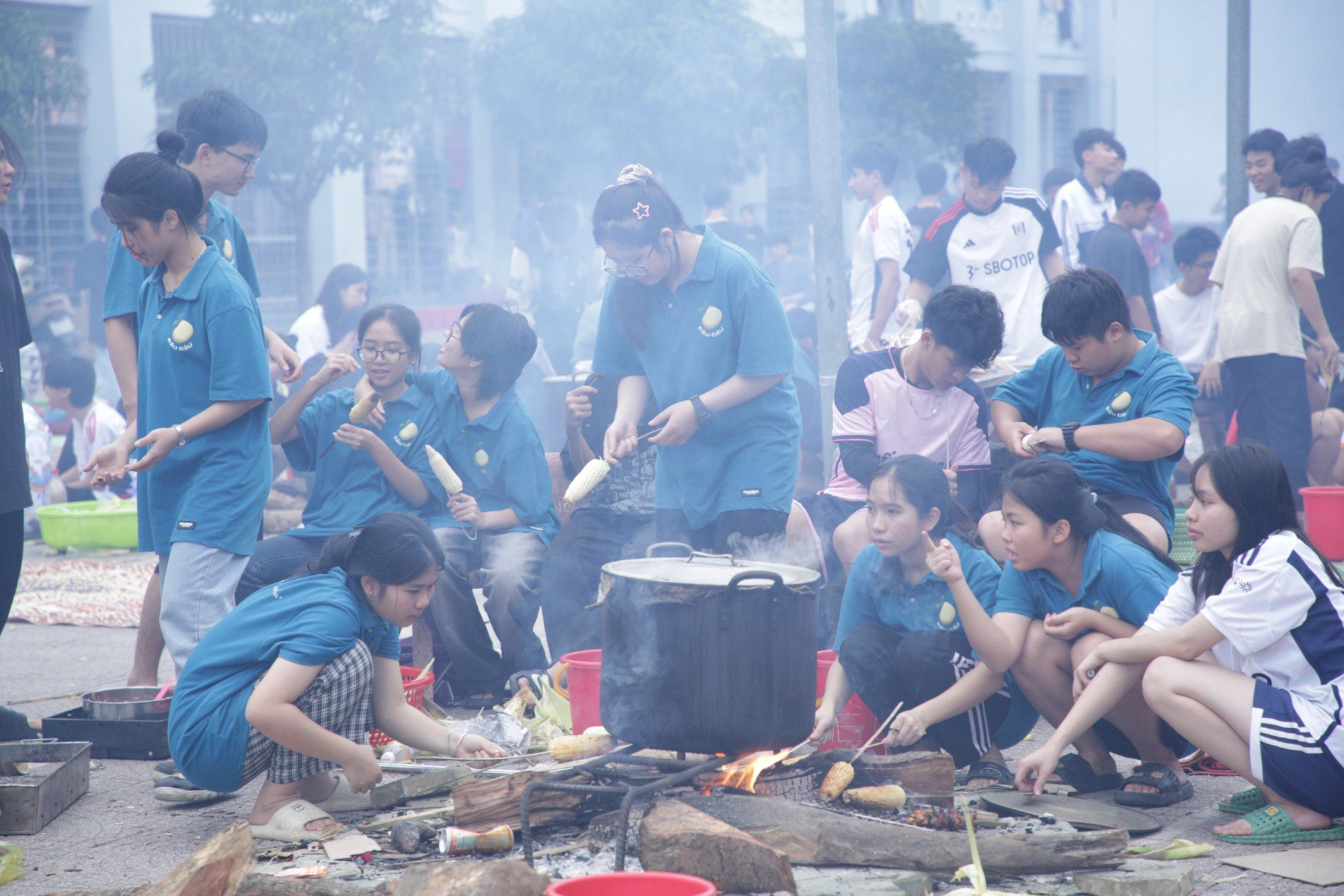 Sau khi gói bánh, các em học sinh phân thành từng nhóm cùng ngồi nấu bánh với nhau - Ảnh: Văn Đạt