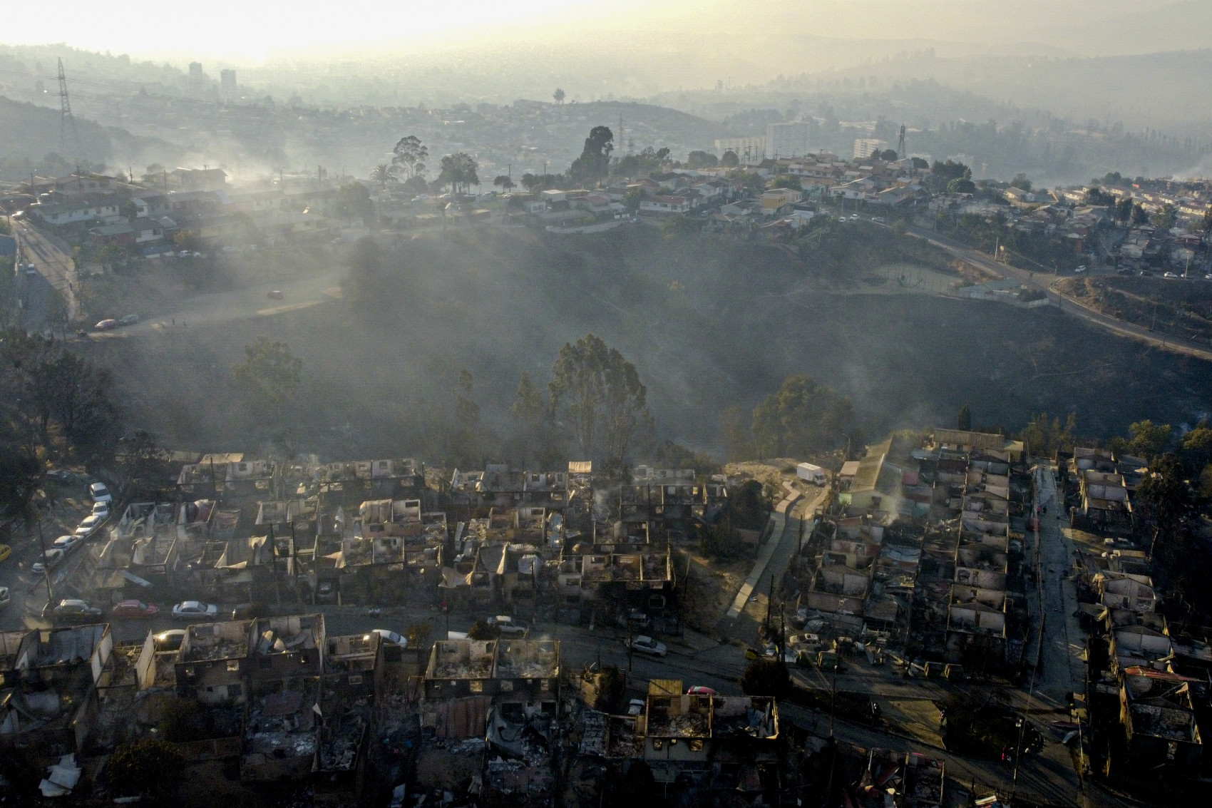Khói bốc lên từ những ngôi nhà bị cháy sau khi cháy rừng lan đến khu phố Villa Independencia ở Vina del Mar, Chile.