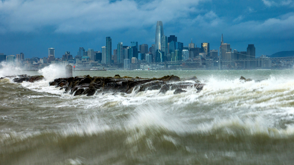 Sóng ập vào đê chắn sóng ở Alameda, California, với nền là đường chân trời San Francisco vào ngày 4/2 - Ảnh: Noah Berger/AP