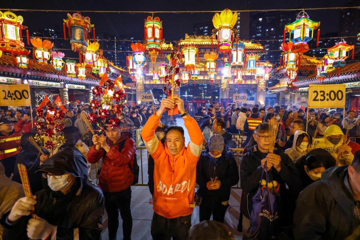 Những người thờ cúng dâng hương đầu tiên tại chùa Wong Tai Sin vào đêm giao thừa âm lịch, như một phần của lễ hội chào đón Năm con Rồng. Ảnh: Yik Yeung-man/SCMP