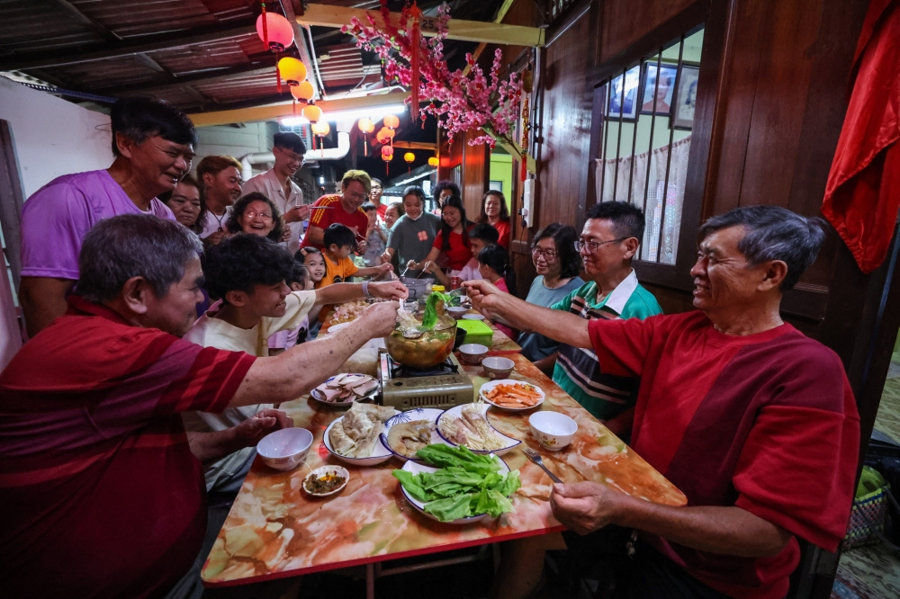 Ông Lim Chin Ewe (69 tuổi, bìa phải) tận hưởng niềm vui đoàn tụ cùng gia đình tại nhà riêng ở Penang, Malaysia vào tối 9/2/2024 – Bernama pic