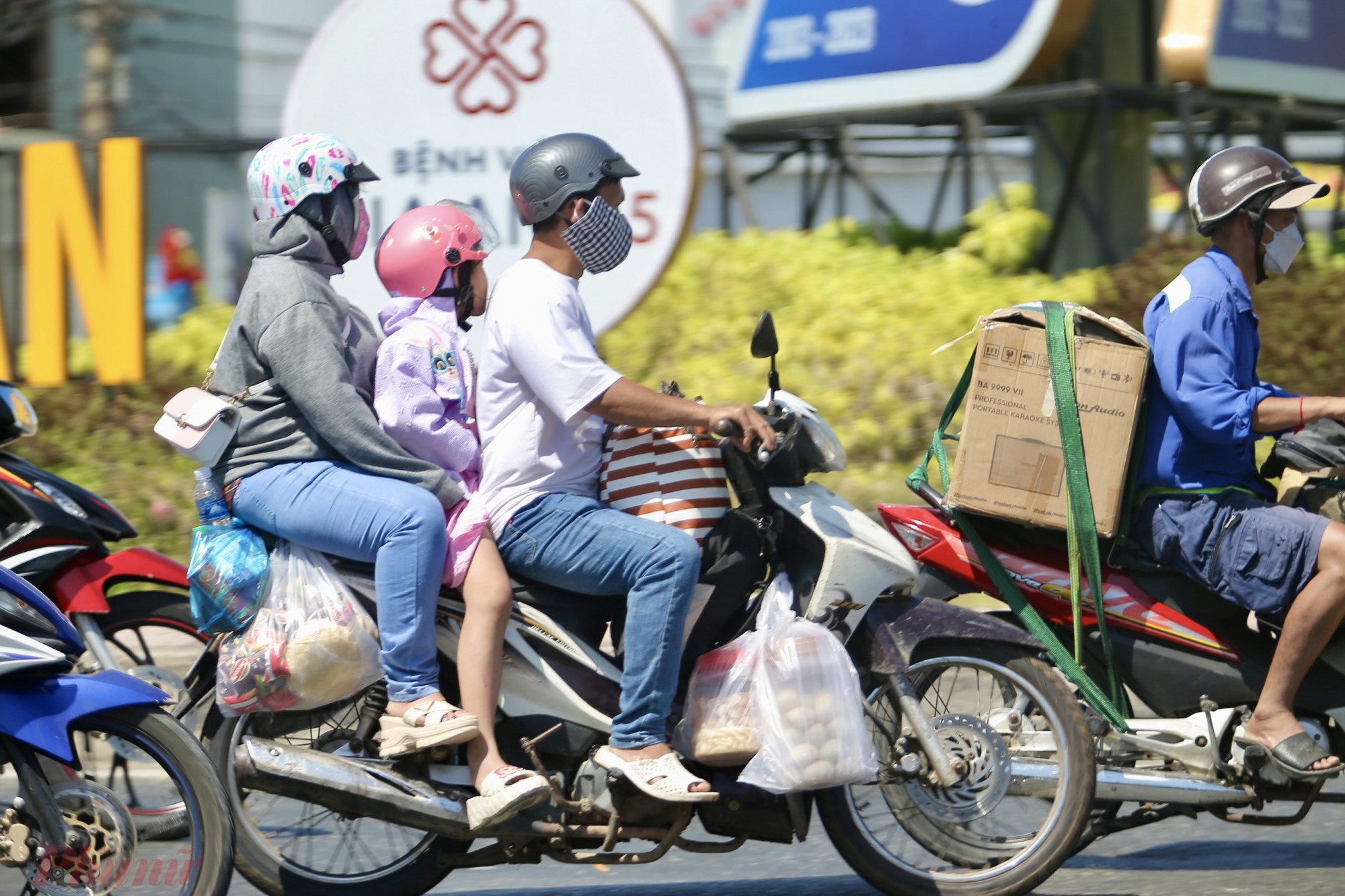 Một gia đình với lỉnh kỉnh đồ đạc treo phía sau xe quay lại thành phố.