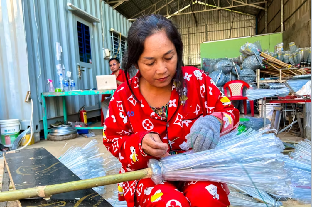 Công nhân đang sản xuất chổi từ những chai nhựa được tái chế - Ảnh: Reuters 