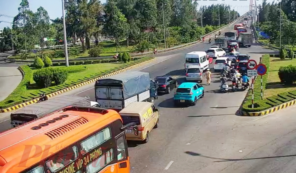 Tại chân cầu Rạch Miễu (phía bờ tỉnh Tiền Giang), lực lượng CSGT “đội nắng” xuống đường điều tiết giao thông