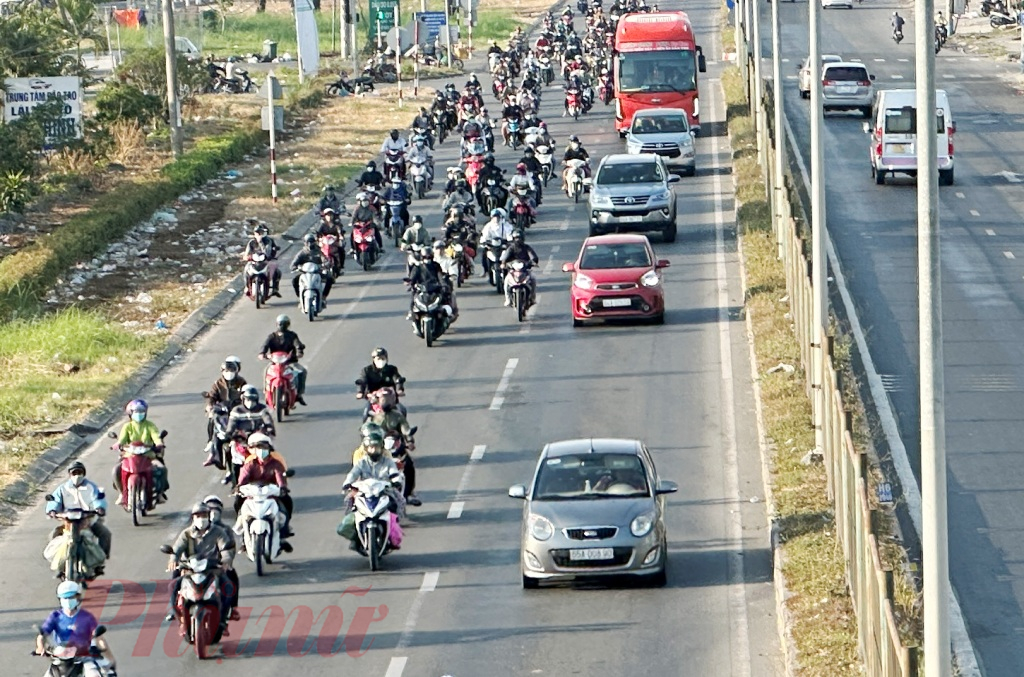 Trên quốc lộ 1 (đoạn xã Hòa Phú, huyện Long Hồ, tỉnh Vĩnh Long), hàng nghìn phương tiện xe mô tô đang di chuyển hướng từ miền Tây đi TPHCM