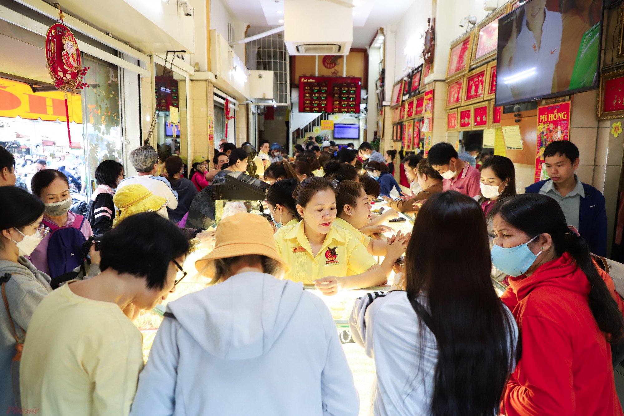 Bên trong cửa hàng, khách phải chen chân để mua. Tuy nhiên theo các nhân viên thì nếu so với các thời điểm ngày vía Thần Tài các năm trước dịch COVID-19 thì lượng khách này là ít hơn khoảng 30-40% - Ảnh: Nguyễn Quang